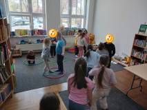 Dzieci stoją na dywanie w hula hop podczas zabawy integracyjnej