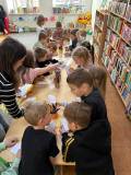 Dzieci przy stolikach wykonują pracę plastyczną