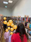 Bibliotekarka oprowadza dzieci po bibliotece 