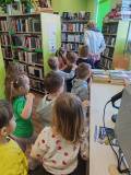 Bibliotekarka oprowadza dzieci po bibliotece