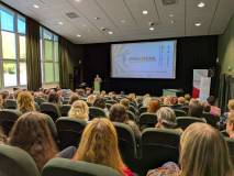 Uroczysta inauguracja w auli Zdjęcie przedstawia widok z tyłu sali na wypełnioną publicznością aulę.