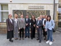 Grupowy portret dziesięciu osób przed wejściem do budynku.

Postacie: Pięciu mężczyzn i pięć kobie