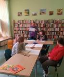Bibliotekarka pokazuje uczestnikom napis Biblioteka.