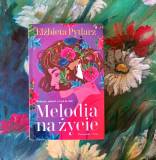 Na zdjęciu książka Melodia na życie, a w tle kwiaty. 