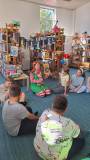 bibliotekarka pokazuje dzieciom książkę o Pippi
