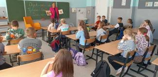 Bibliotekarka pokazuje dzieciom książki Niesforne ziarenko i  Naprawdę chcę krzyczeć.