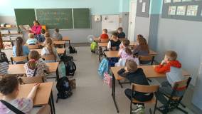 Bibliotekarka czyta książkę Naprawdę chcę krzyczeć, uczniowie siedzą w ławkach i słuchają.