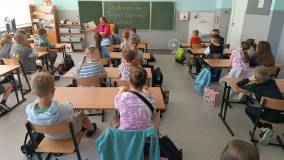 Bibliotekarka czyta książkę Niesforne ziarenko, uczniowie słuchają.