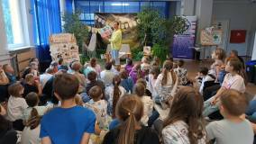 Bibliotekarka czyta uczniom książkę Żółty groszek. Nieśmiały przyjaciel.