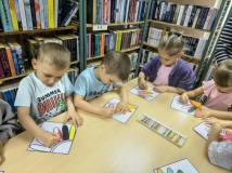 Przedszkolaki kolorują płatki kwiatów.