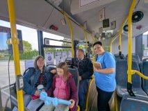 Wnętrze autobusu tematycznego MZK z dekoracjami bibliotecznymi zawieszonymi pod sufitem. Pracownica 