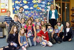 Pamiątkowe zdjęcie prowadzącej i uczestników zajęć plastycznych w ramach „Wakacji w Bibliotece” w Ko