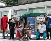 Czytanie utworów Aleksandra Fredry na placu przed Koszalińską Biblioteką Publiczną