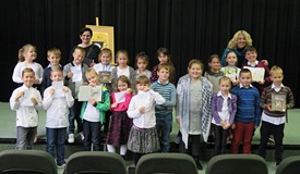 Młodzi czytelnicy wraz z Anną Onichimowską na wspólnym zdjęciu w Koszalińskiej Bibliotece Publicznej