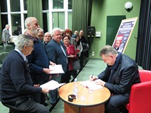 Wiesław Romanowski rozdaje autografy w czasie spotkania autorskiego w Koszalińskiej Bibliotece Publi