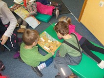 Dzieci czytają książeczki na materacykach