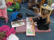 Dzieci oglądają książki na materacach