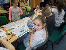 Dziecko pozuje do zdjęcia z gotową pracą plastyczną