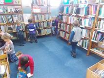 Dzieci wybierają książki z regałów