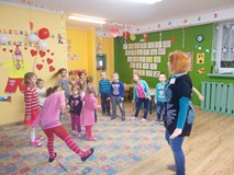 Dzieci wraz z bibliotekarką tańczą w rytm muzyki