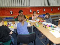 dzieci siedzą przy stole i malują