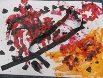 praca plastyczna przedstawiająca złe emocje w oczach dziecka, połączenie czerni, czerwieni i pomarań