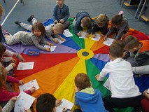 Dzieci kolorują ilustracje na chuście