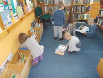 Dzieci oglądają książeczki w kąciku malucha