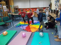 Dzieci biegną do materacy, na których leżą balony