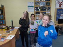 Dzieci pozują do zdjęcia ze swoją pracą w drużynie