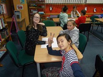 Dzieci siedzą przy stołach w drużynach