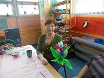 Pani pozuje do zdjęcia ze swoim rękodziełem