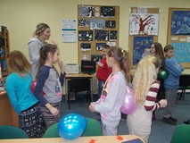 dzieci stoją w parach odwrócone plecami do siebie z balonem pomiędzy nimi