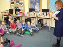 Bibliotekarka pokazuje ilustracje zimowe z książki dzieciom