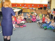 Dzieci siedzą i naśladują ruchy bibliotekarki