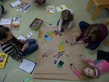 Grupa dzieci rysuje mapę okolic biblioteki.