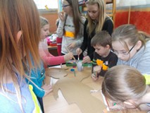 Dzieci stoją i malują detektywa z kartonu