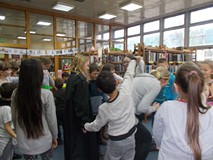 Dzieci z bibliotekarką trzymają się za ręce podczas zabawy