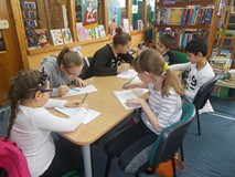 Dzieci siedzą przy stole i rysują