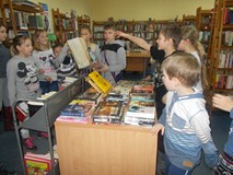 Dzieci stopją przy stole i trzymają w ręku znalezioną nagrodę