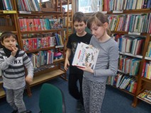 dzieci wyciągają ukrytą w książce kopertę