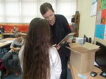 Bibliotekarka wręcza dziewczynce nagrodę