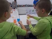 Chłopcy przelewają kolorowy płyn