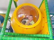 Chłopec uśmiecha się do zdjęcia na zjeżdżalni