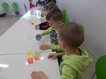 Dzieci przelewają kolorową wodę do kubkach