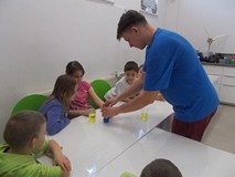 Prowadzący dzieciom pokazuje eksperyment