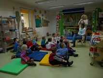 Sala Muminków w filii nr 9. Na kolorowych materacach siedzą przedszkolaki. Po lewej stronie zdjęcia,