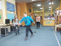 Bibliotekarka stoi przed dziećmi, które biegną