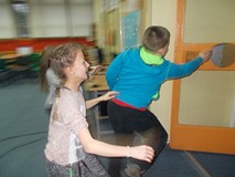 Troje dzieci biegnie do kółka przyklejonego na drzwiach