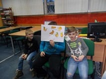 Trzech chłopców pozuje do zdjęcia ze swoją pracą